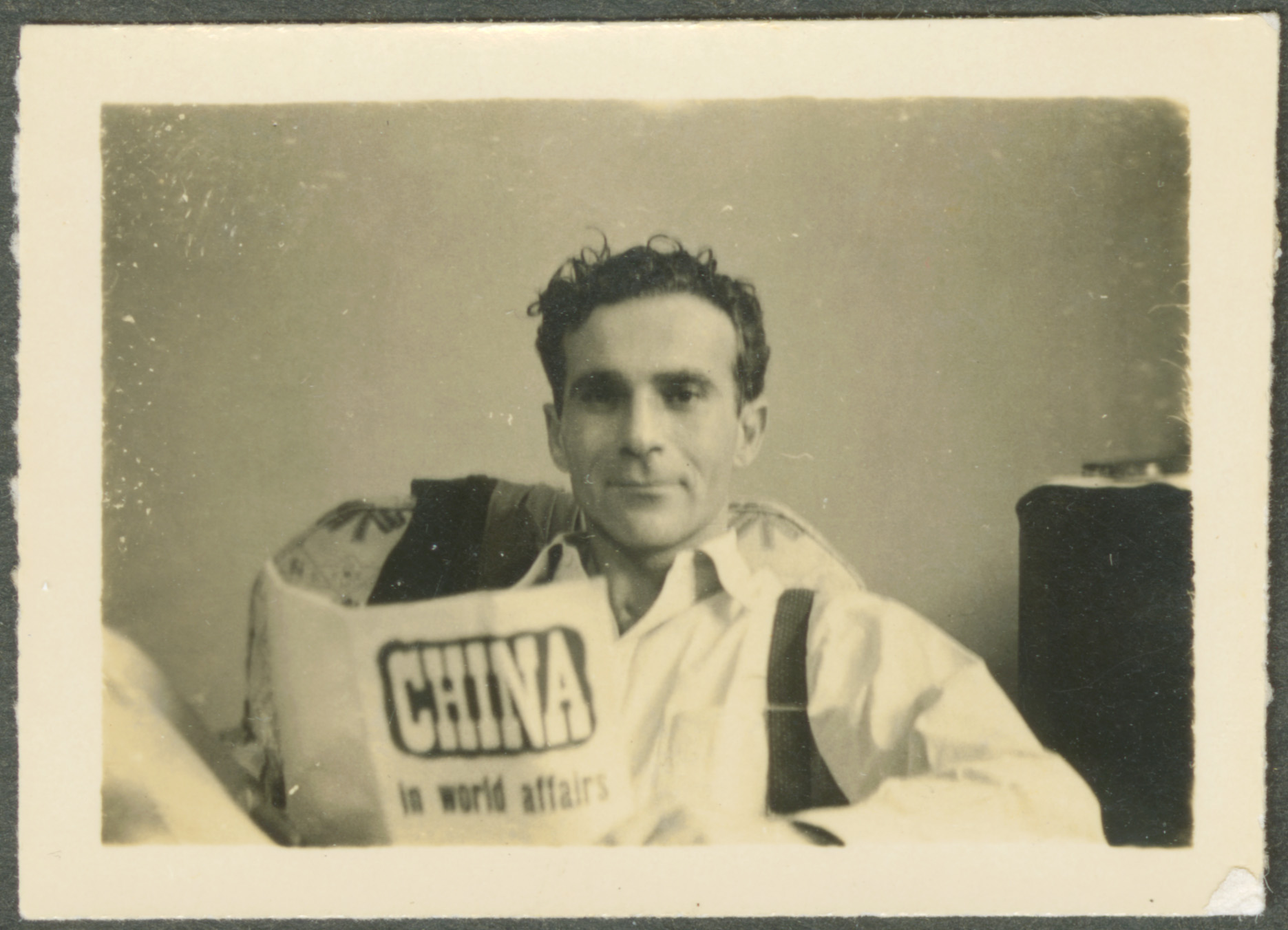 Photograph of man sitting reading a newspaper. Edgar Snow in Shanghai, China